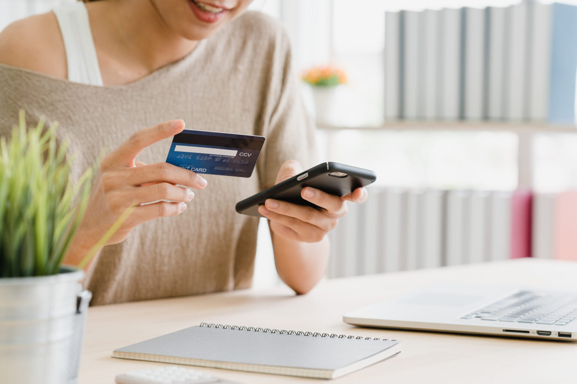 Woman holding credit card and mobile phone for payment | Webface