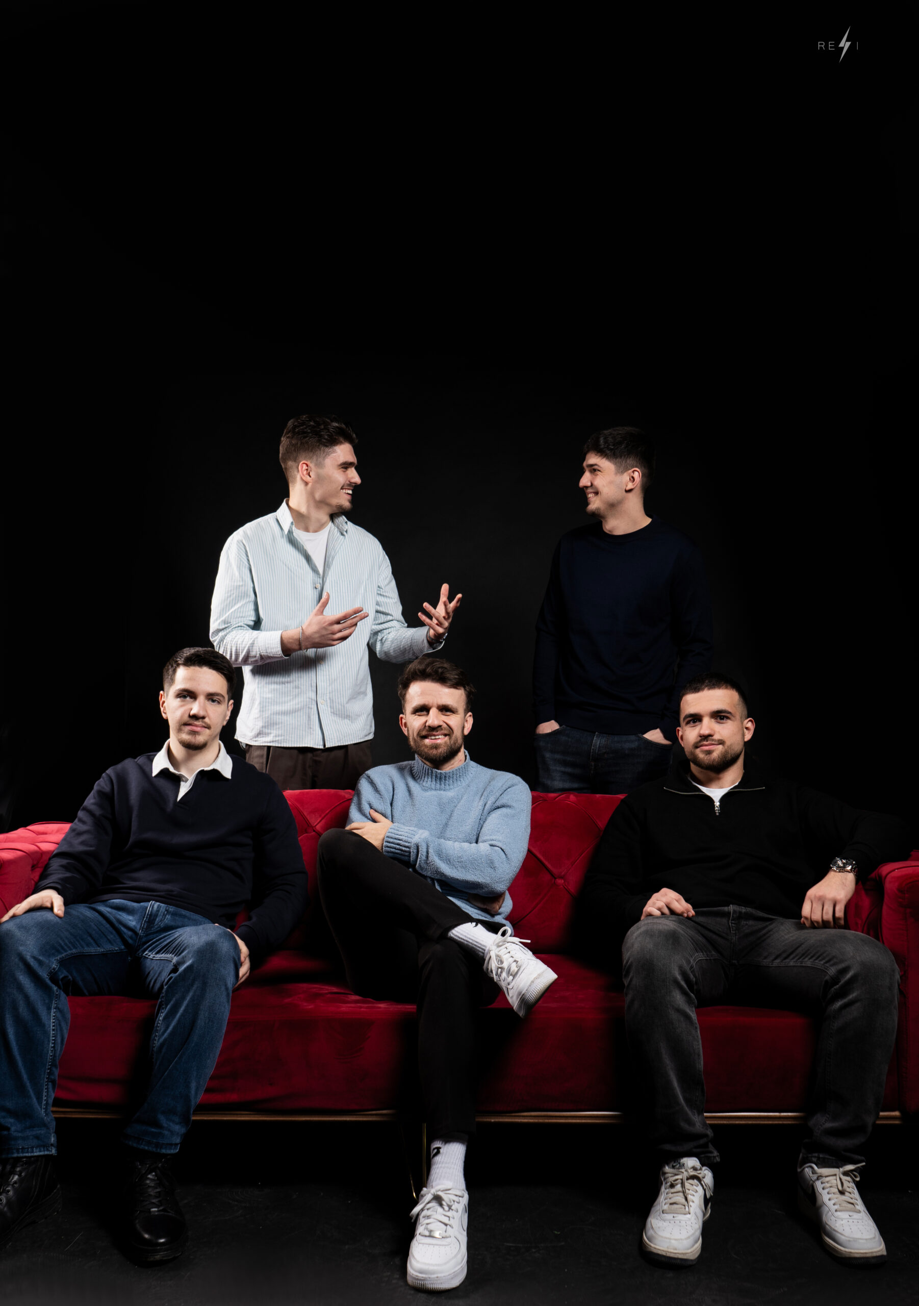 Webface team photo on red sofa with black background | Webface