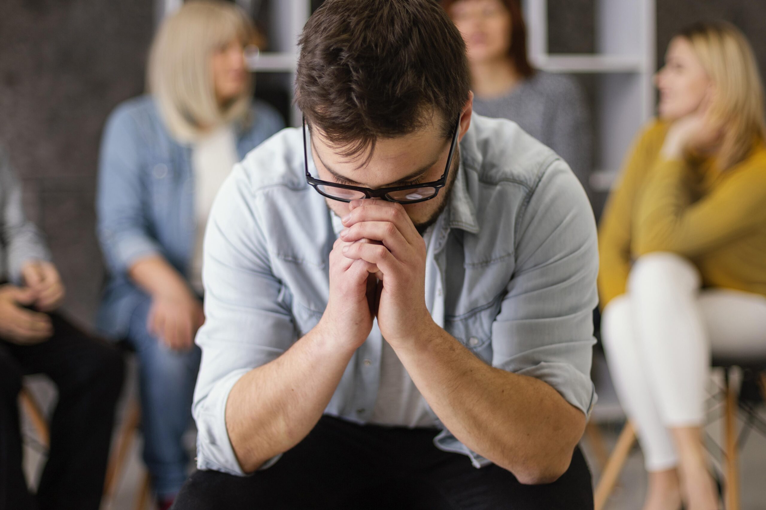 Worried man in group therapy representing emotional risks and ethical concerns of AI chatbots | Webface