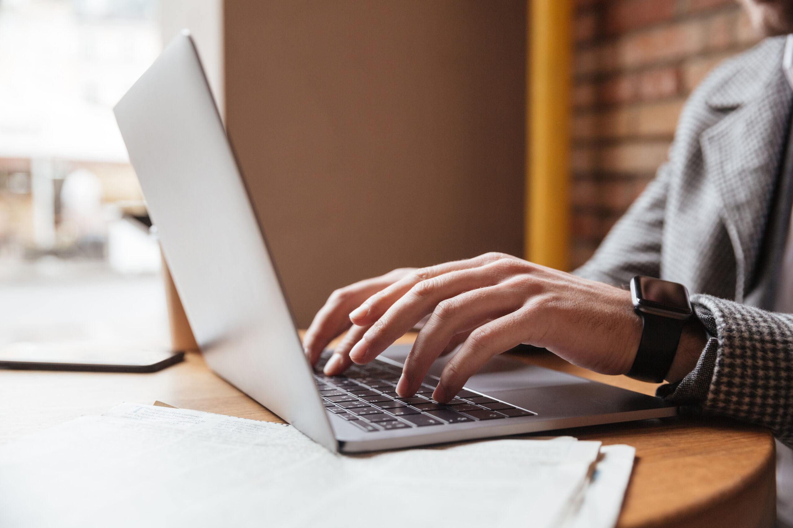 Businessman typing on laptop in a café setting | Webface