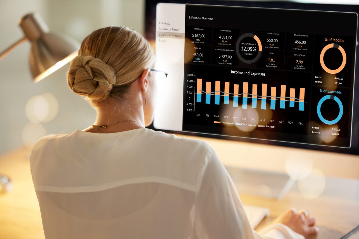 Female marketing analyst reviewing business performance dashboards and financial analytics on a computer screen | Webface
